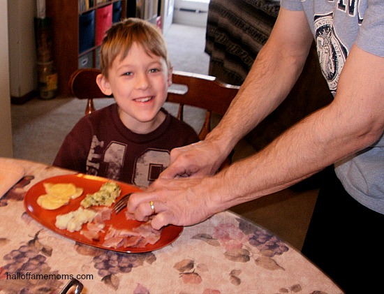 dad cutting son's ham