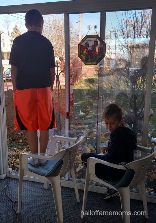 The boys watch the drain company repair the sewer pipes.